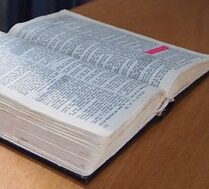 open bible on table with cup of tea